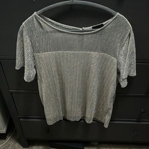 Flowy top with a tan base and silver overlay. Flounced sleeves .